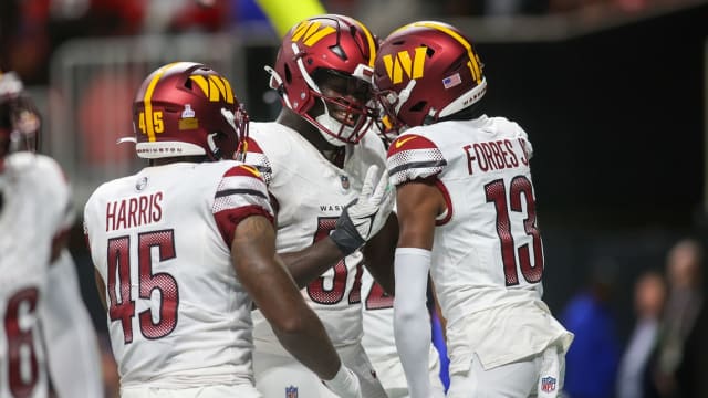 Oct 15, 2023; Atlanta, Georgia, USA; Washington Commanders linebacker Jamin Davis (52) reacts after an interception with linebacker De'Jon Harris (45) and cornerback Emmanuel Forbes (13) against the Atlanta Falcons in the second half at Mercedes-Benz Stadium.